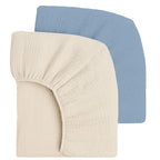 Two fitted crib sheets, one cream and one light blue, on a white background.