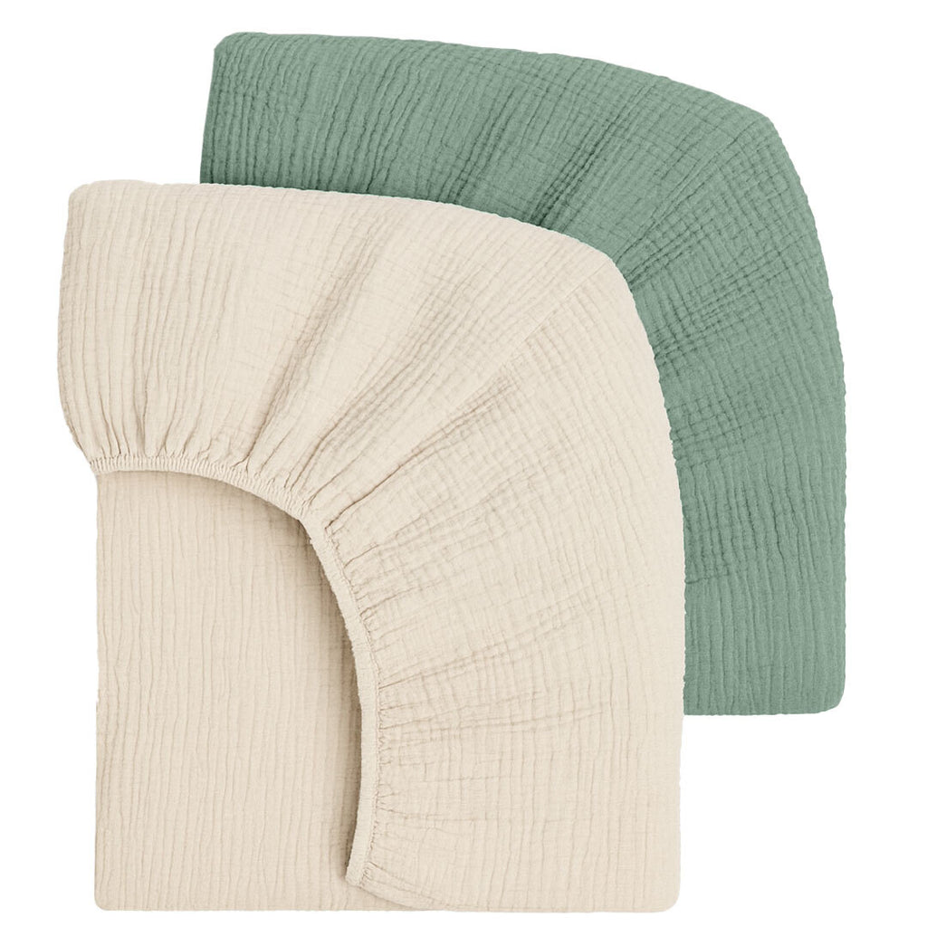 Two fitted crib sheets, one cream and one light green, on a white background.