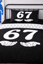 Close-up of 6-7 black twin duvet cover and matching pillow with white number 67 cartoon design, reversible bedding set